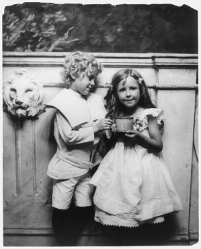 boy_and_girl_posed_standing_holding_large_cup.png
